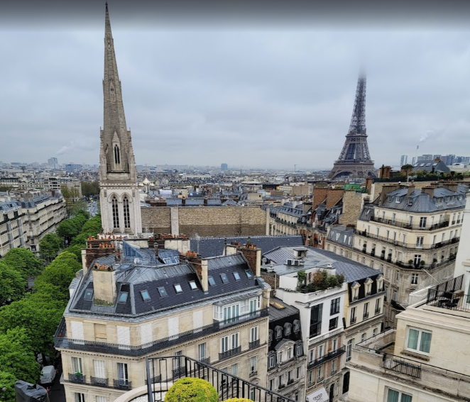 Paris rooftops and the Eiffel Tower beneath a cloudy sky